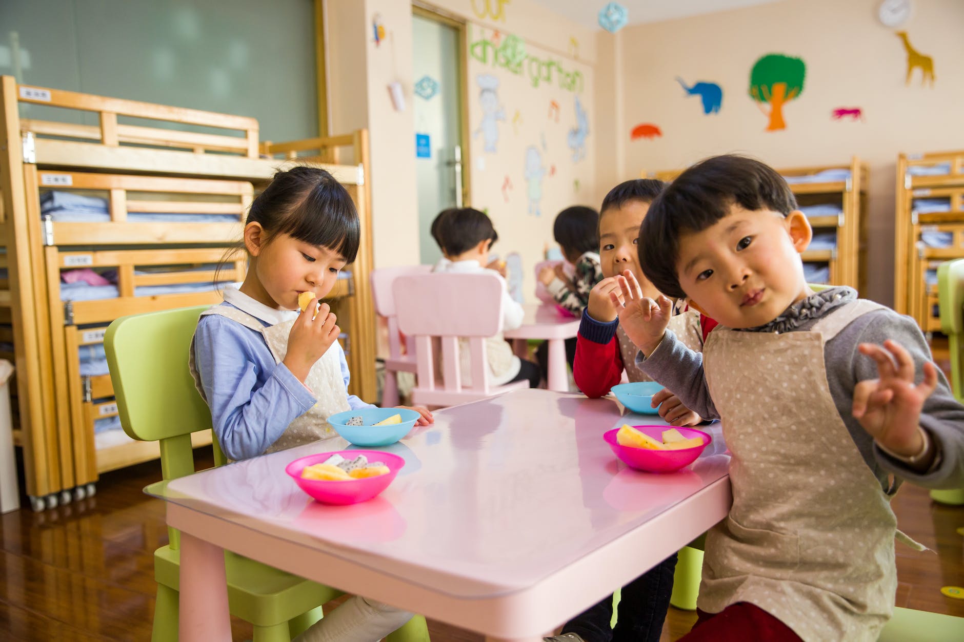 three toddler eating on white table